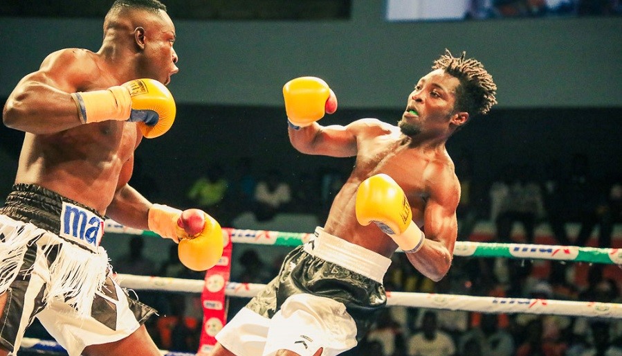 Charles Tetteh of Panix Gym (left) launches an attack on Michael Tagoe of Seconds Out Gym in their featherweight clash